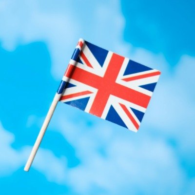 a small british flag flying in the blue sky